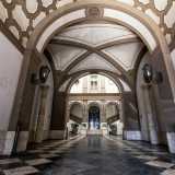 Non ci resta dunque che varcare il portone per entrare nel palazzo, calpestando un pavimento in marmo composto da mattonelle alternate di colore bianco e nero